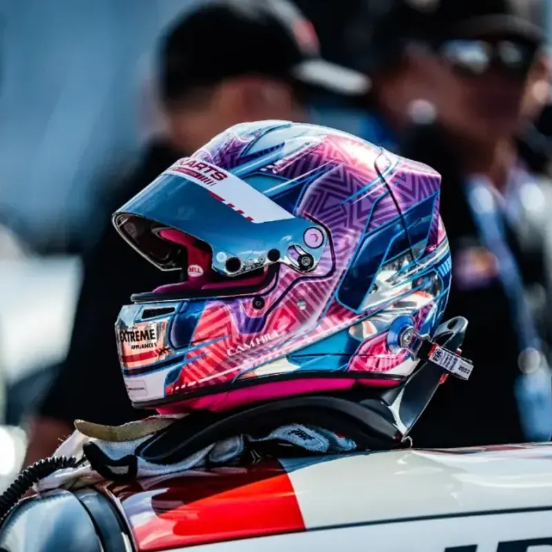Close-up of Cameron’s helmet resting on the roof of the race car.